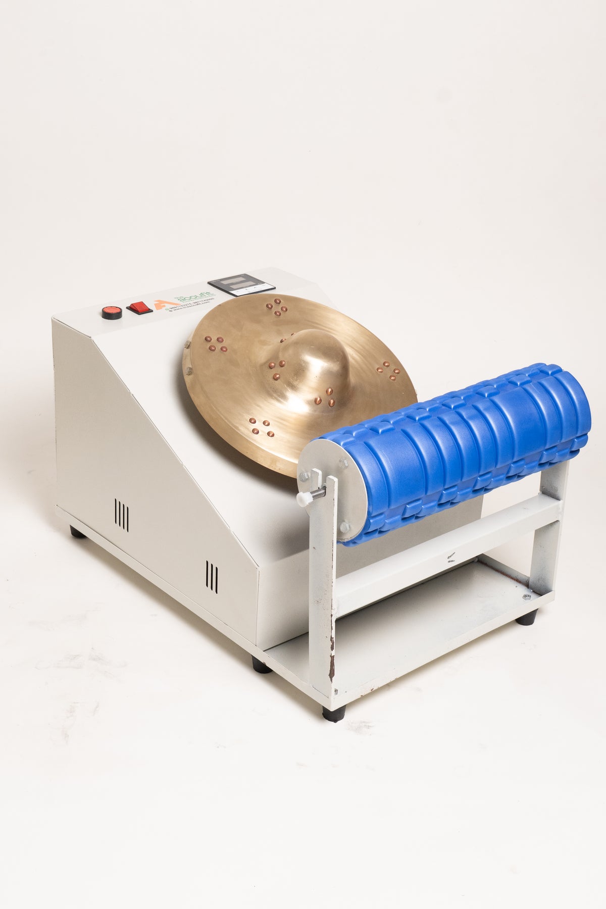 A white and silver metal machine with a circular bronze-colored drum and a bright blue ribbed cylindrical component, photographed on a plain light background.